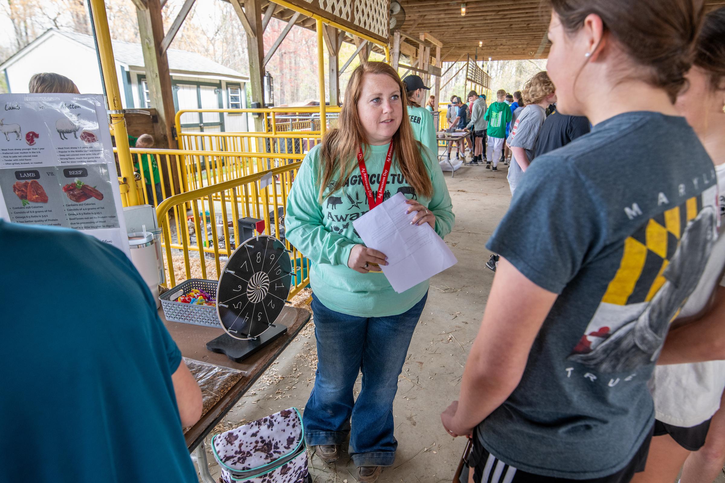 Agriculture Educator Speaking with Attendees at a Livestock Fair or Competition