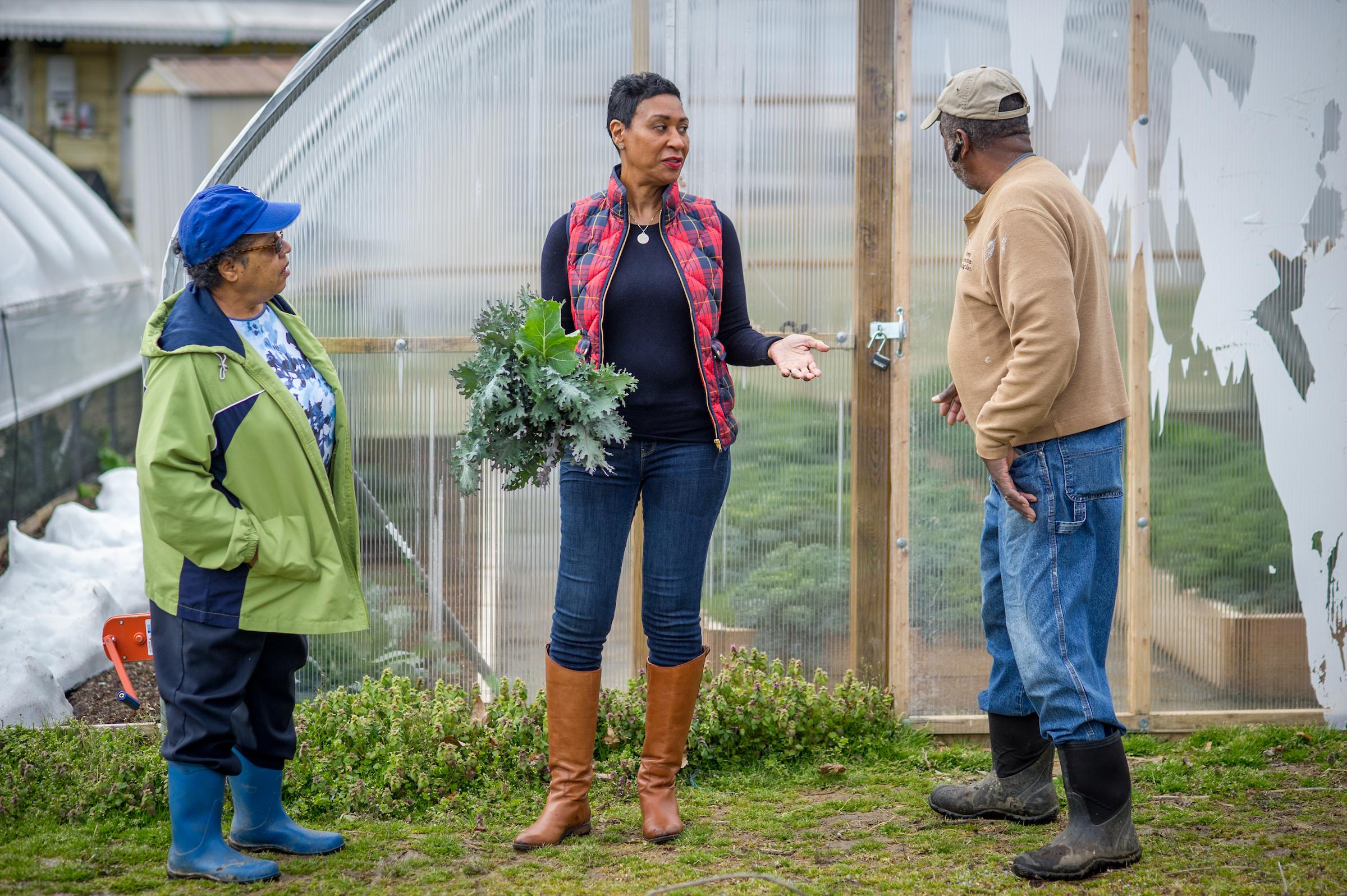 An Extension Agent speaking with two farmers at an urban farm